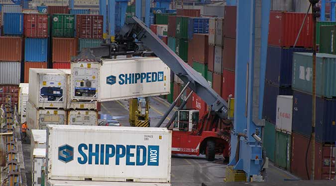 Shipping Container port with Shipped.com containers being unloaded